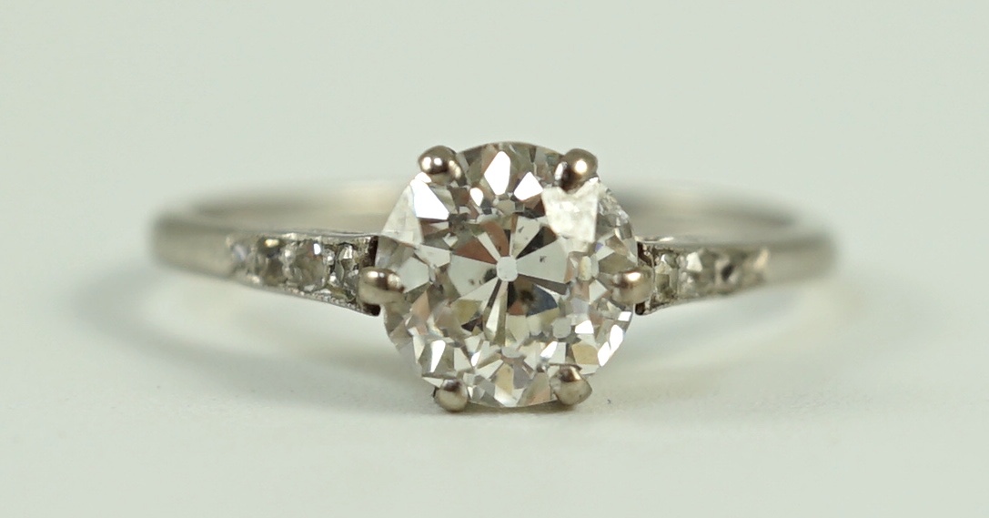 A platinum and single stone diamond ring, with diamond chip set shoulders